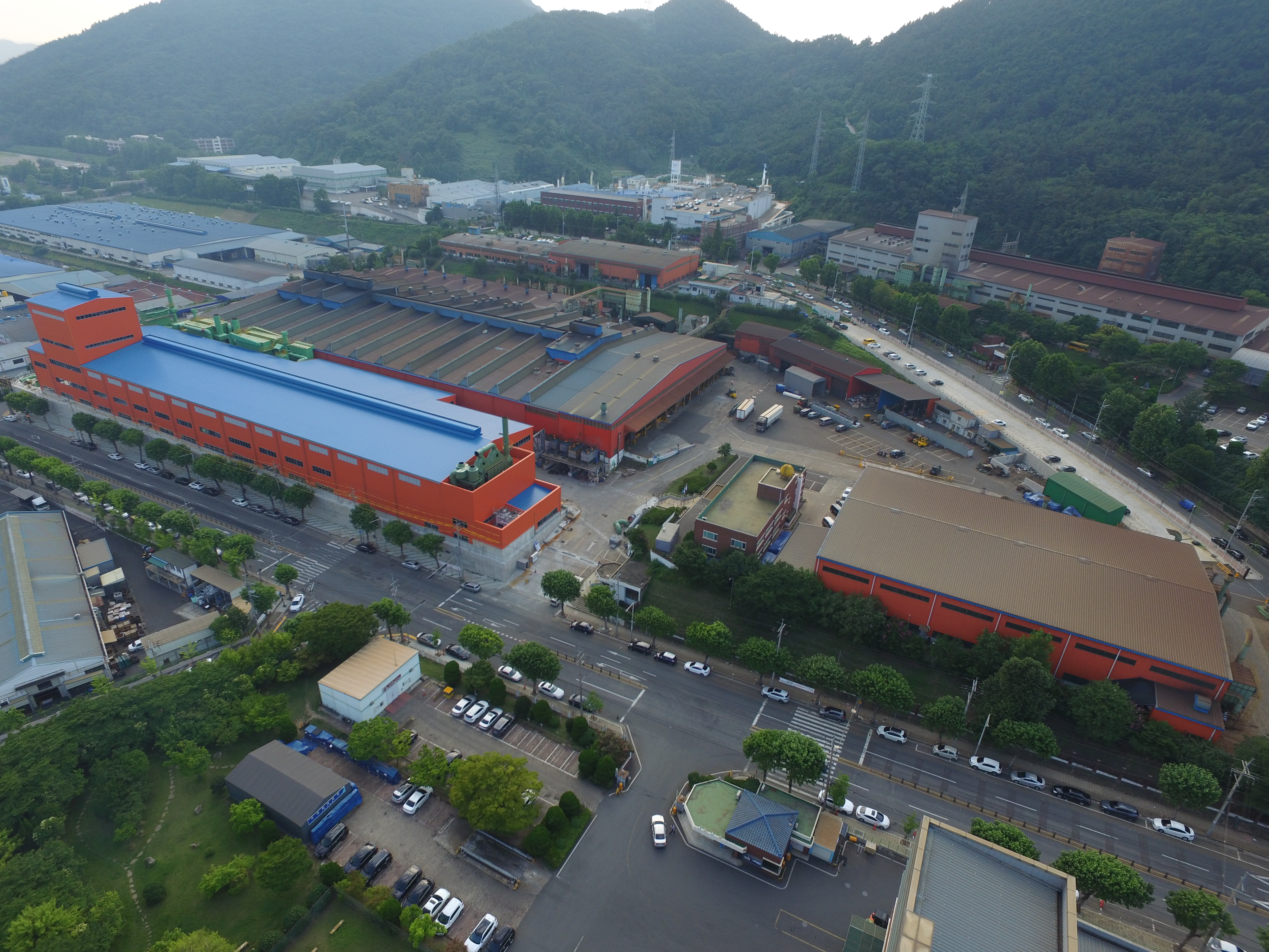 대동금속 주조공장 전경 산과 공장단지에 인접한 대동금속 주조공장 건물과 야적장 전경