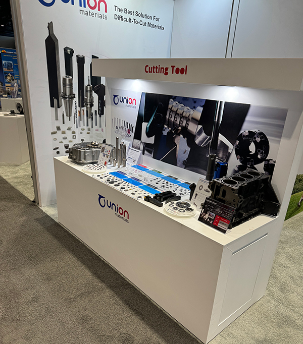IMTS 2024 전시의 절삭공구 제품 전시 유니온머티리얼 전시 부스의 Cutting Tool 표지 아래에 절삭공구와 금속 부품 샘플이 진열된 모습