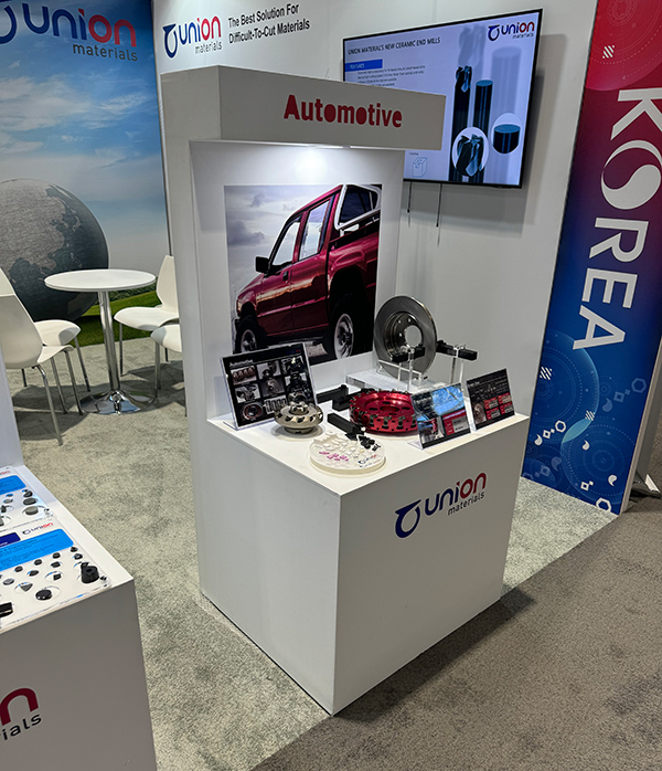IMTS 2024 전시의 자동차용 부품 전시 유니온머티리얼 Automotive 전시대에 자동차 부품과 원형 금속 부품이 진열된 모습