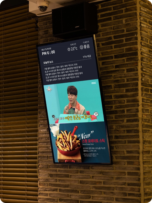 매장 벽면 디지털 사이니지에서 영상과 광고 콘텐츠를 표시한 화면 벽에 설치된 세로형 디스플레이에 방송 영상과 광고가 재생되는 모습