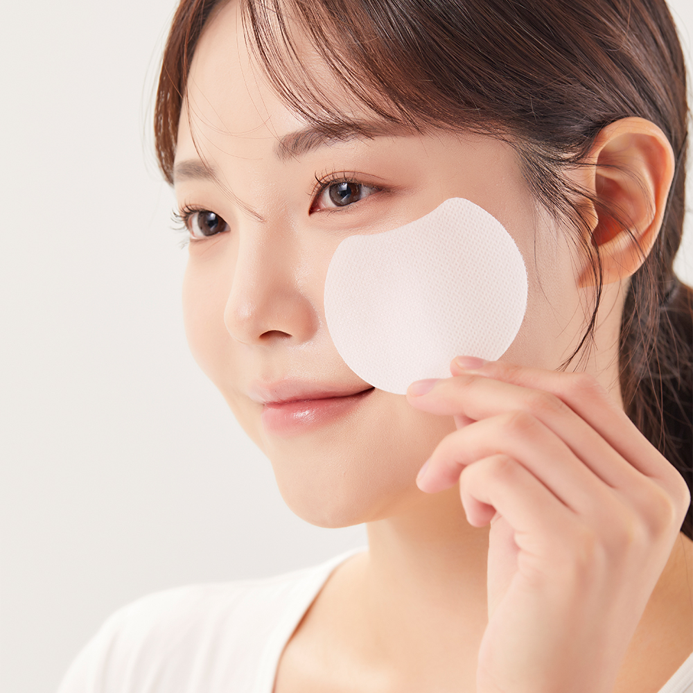 에어퀸 멜팅 콜라겐 필름 사용 장면 여성이 원형 필름을 뺨에 대고 있는 클로즈업