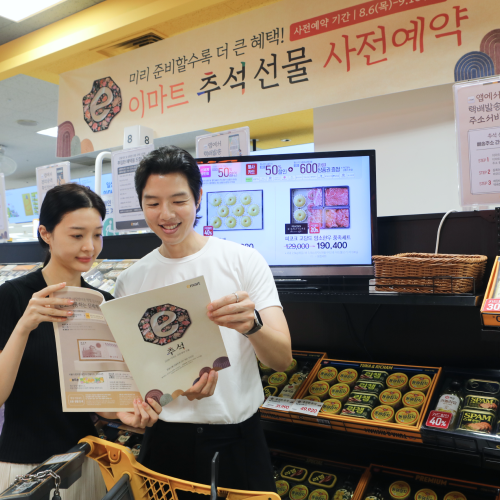 이마트 추석 선물세트 진열대와 고객 추석 선물 사전예약 안내 아래 선물세트 진열대를 살펴보는 고객