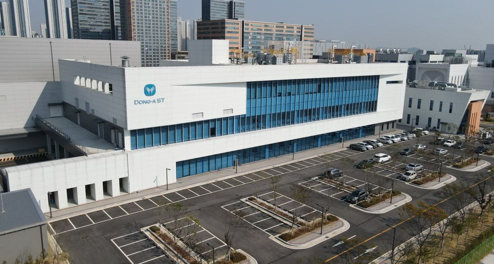 동아ST 제조시설 항공 전경 주차장과 파란 창을 갖춘 동아ST 대형 제조시설 항공 전경