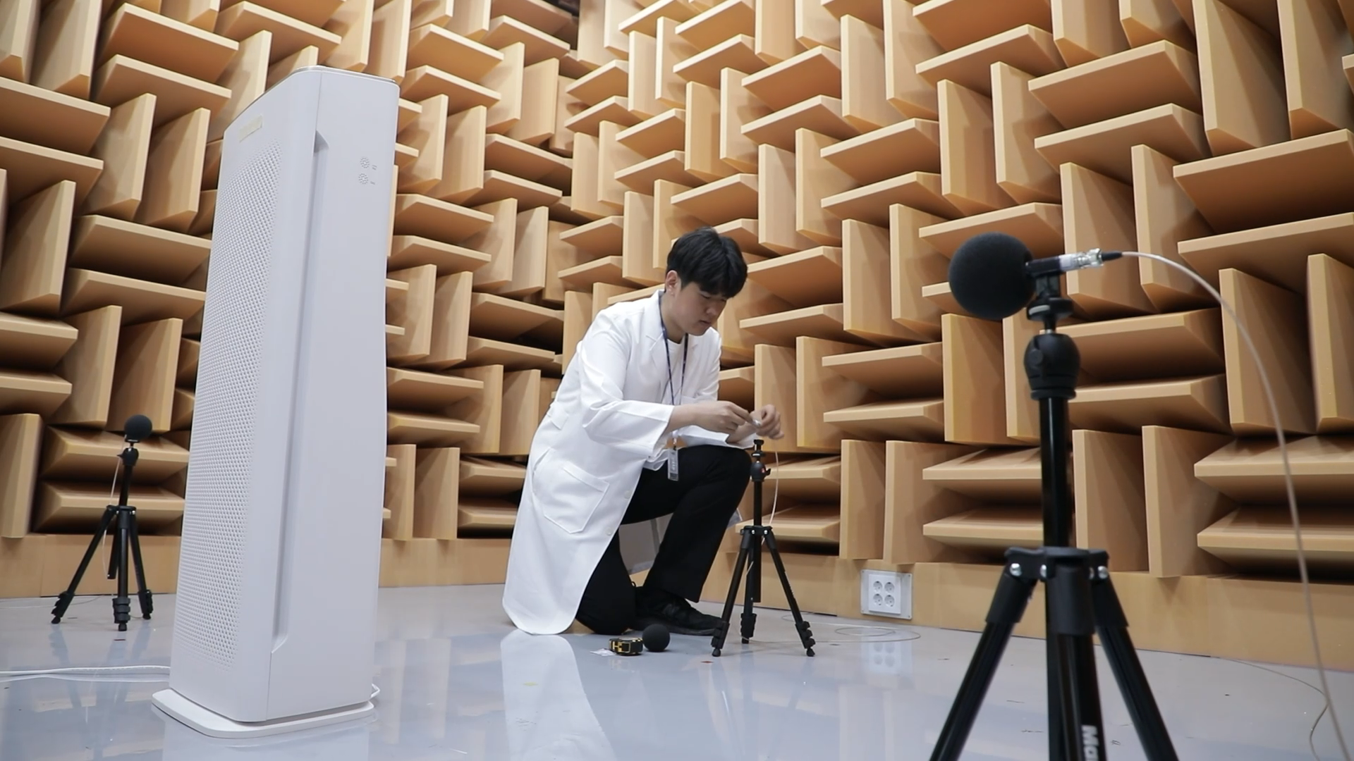 무향 시험실에서 마이크 측정 장비를 설정하는 연구원 목재 흡음 구조 벽면의 무향실에서 측정용 마이크를 조정하는 연구원