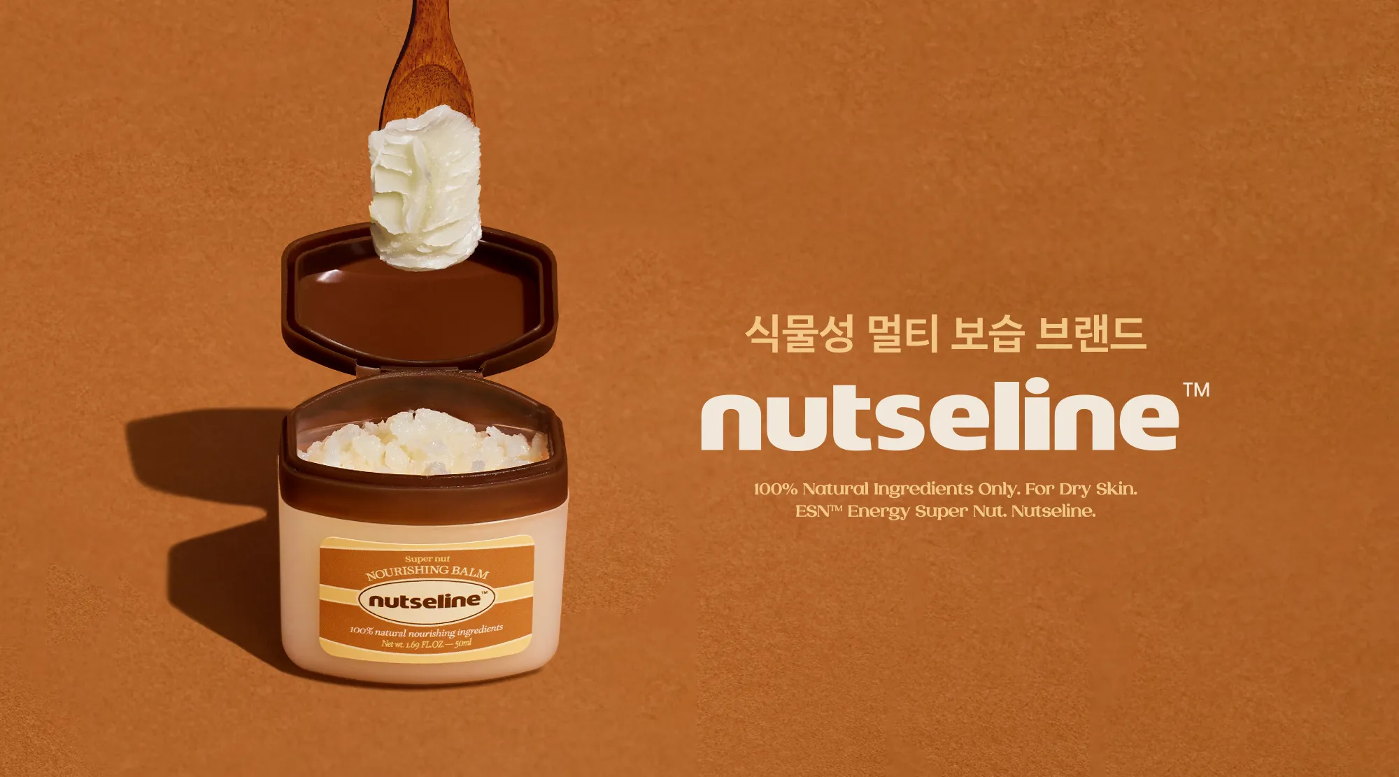 넛세린 식물성 보습 밤 제품과 제형 갈색 배경 위에 열린 넛세린 너리싱 밤 용기와 밤 제형을 든 나무 스푼