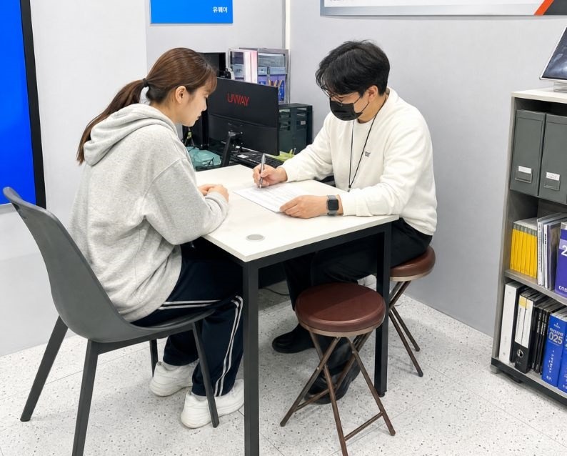 부산캠퍼스의 1:1 학습상담 학습자가 상담자와 책상에서 서류를 보며 상담하는 모습