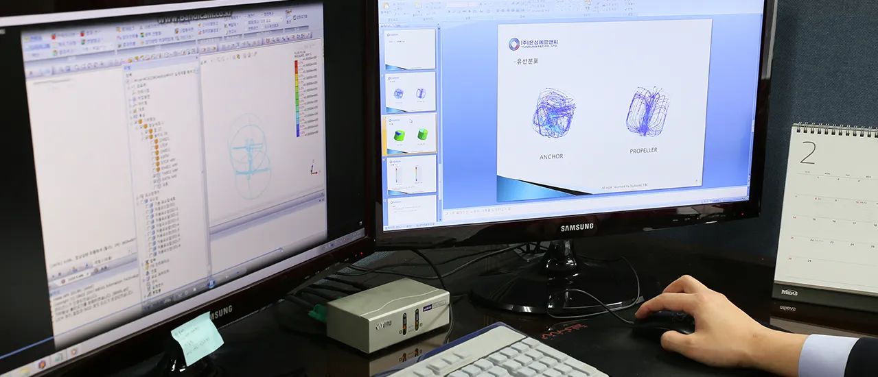 교반기 형상과 유동 해석 모델을 검토하는 CFD 작업 화면 컴퓨터 두 대에 교반기 CFD 모델과 앵커·프로펠러 형상 슬라이드가 표시된 작업 화면