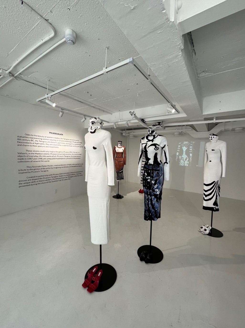 ALAÏA 의상과 마네킹으로 구성된 패션 전시 설치 흰 전시 공간에 흑백 패턴의 의상과 마네킹이 설치된 ALAÏA 패션 전시
